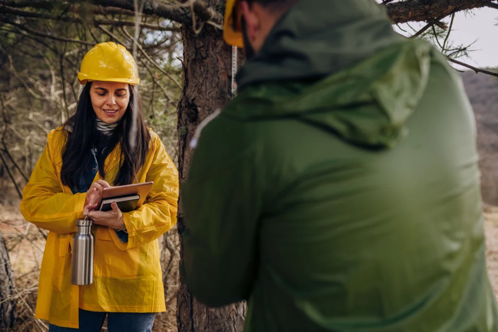 man and woman performing biological surveys in a forest